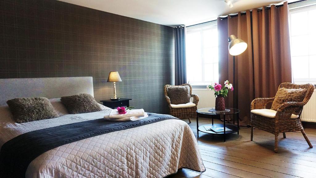 オルシュティンにあるDK Apartament Stare Miastoのベッドルーム1室(ベッド1台、椅子2脚付)