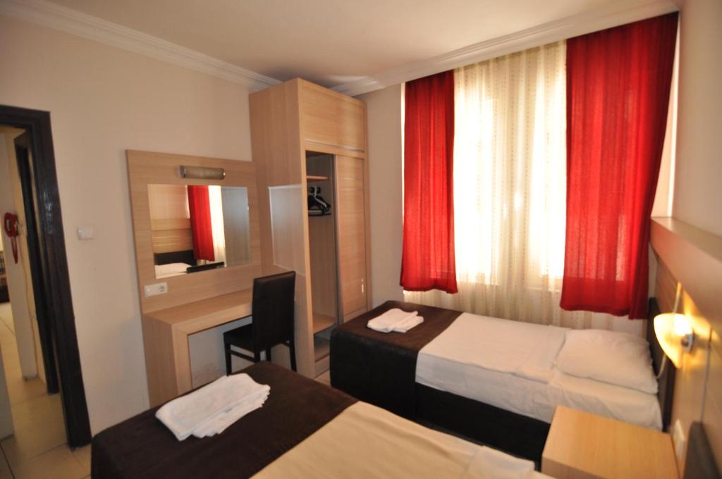 アランヤにあるBest House Apart 1のベッド2台とデスクが備わるホテルルームです。