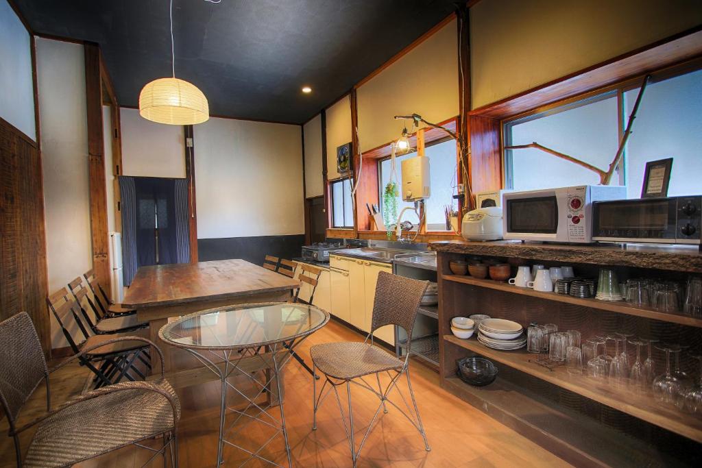 a kitchen with a glass table and some chairs at Yoshimura Kajihara-Tei in Fujikawaguchiko