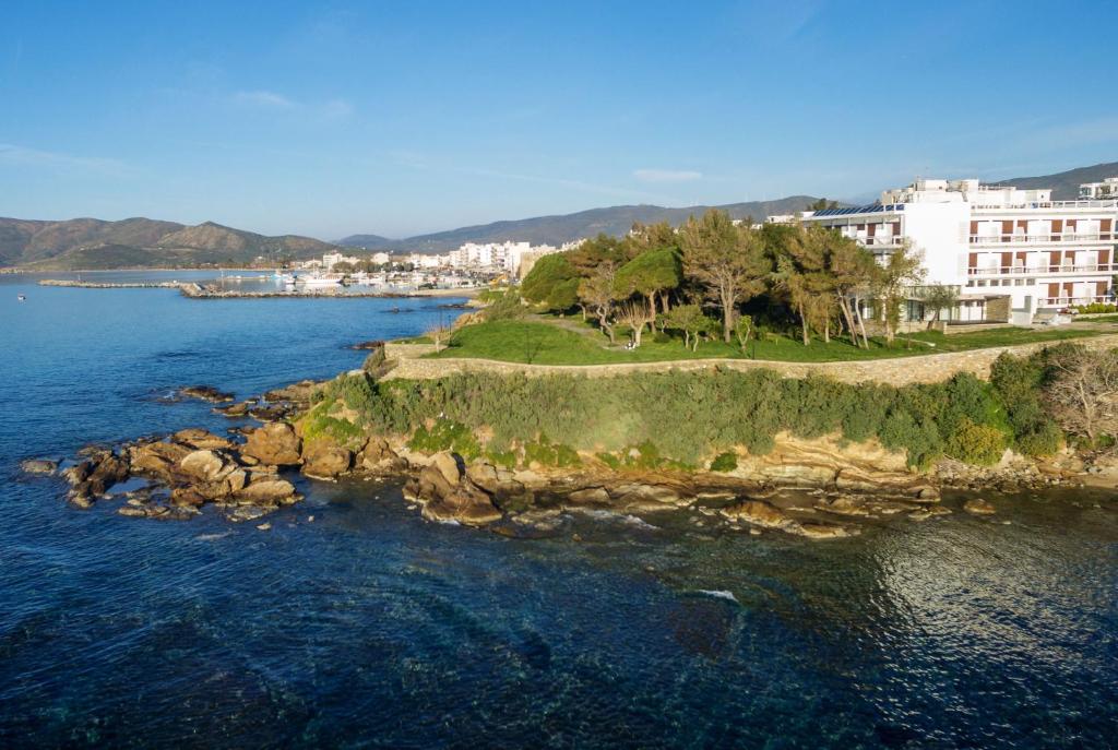 una isla en el agua al lado de un edificio en Karystion Hotel en Karistos