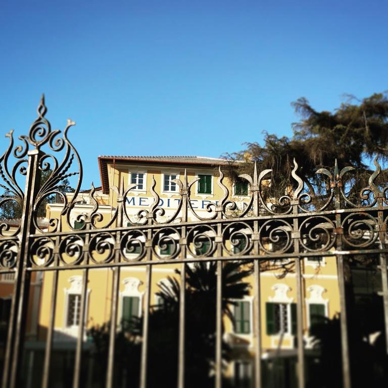 an ornate fence in front of a yellow building at Mediterraneo Emotional Hotel & Spa in Santa Margherita Ligure