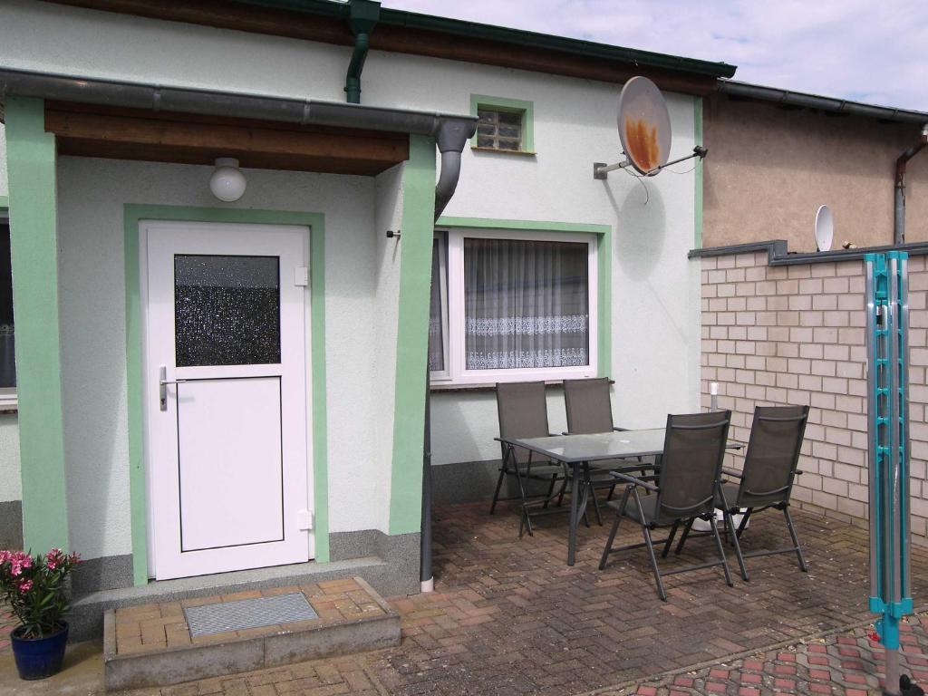 a patio with a white door and a table and chairs at Ferienwohnung Raddatz in Korswandt