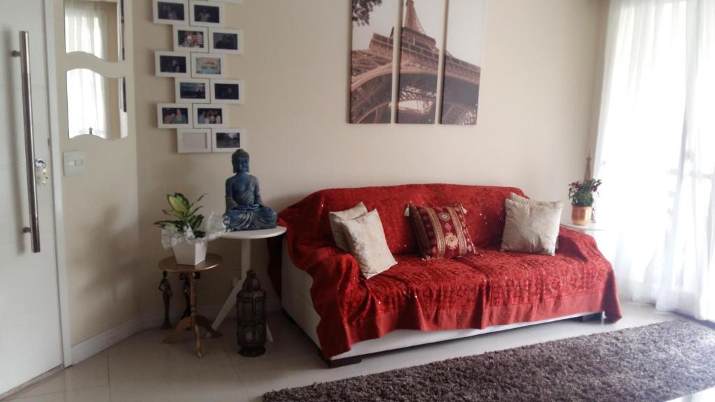 sala de estar con sofá rojo y almohadas en Apartamento Resort Morumbi, en São Paulo