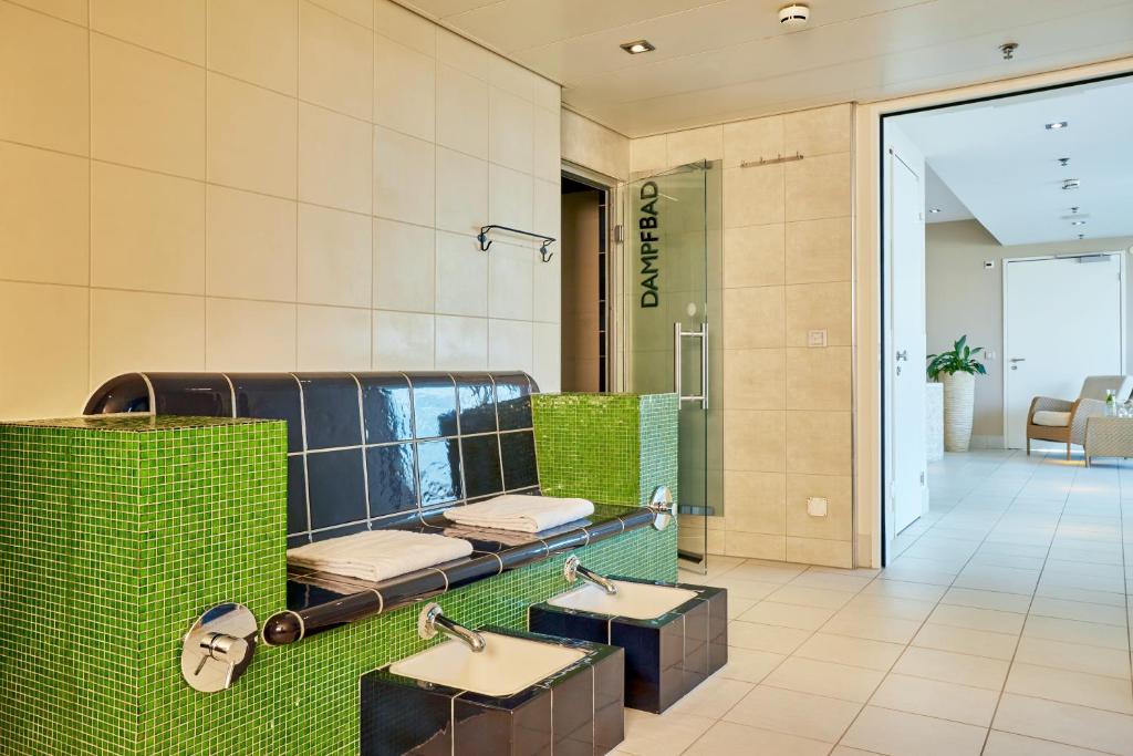 uma casa de banho com dois lavatórios num quarto em H4 Hotel Solothurn em Solothurn