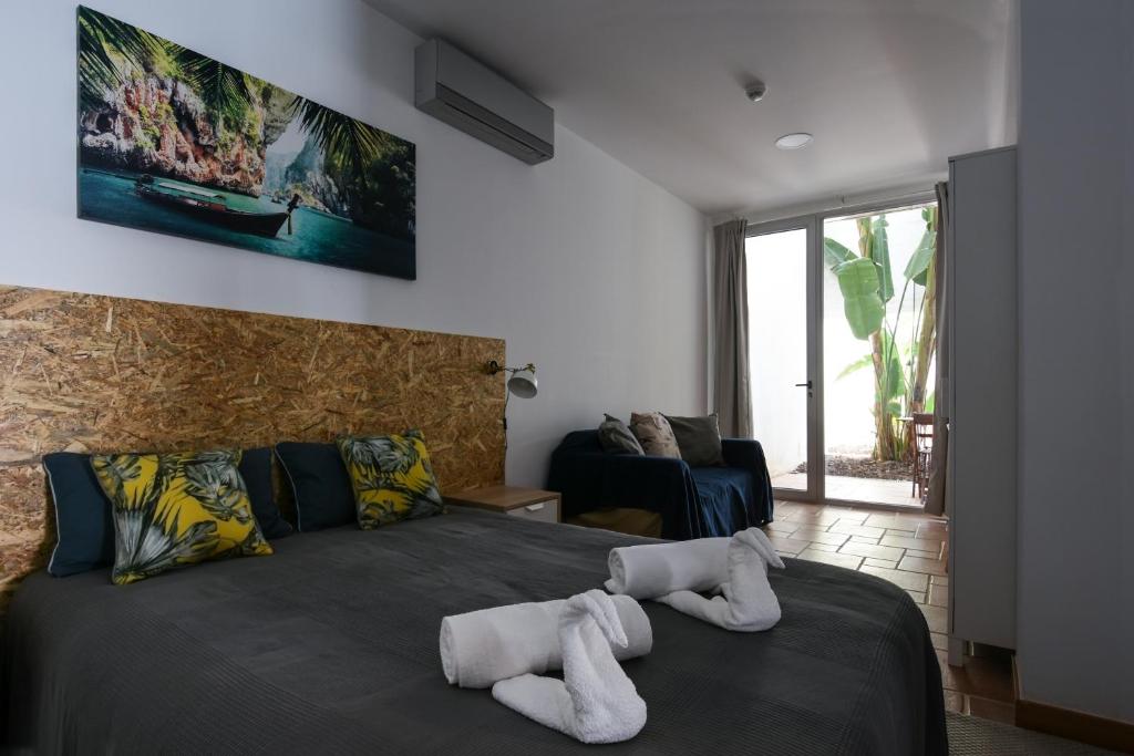 una camera da letto con un letto e asciugamani di Pé na Areia - Guest House a Vila Real de Santo António