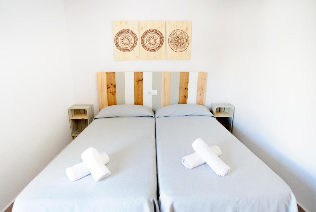 Un dormitorio con una cama con cruces. en Apartamentos Marian, en San Antonio