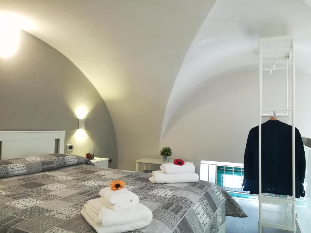 1 dormitorio con 1 cama con toallas en appartamento sabbia dell' etna en Catania