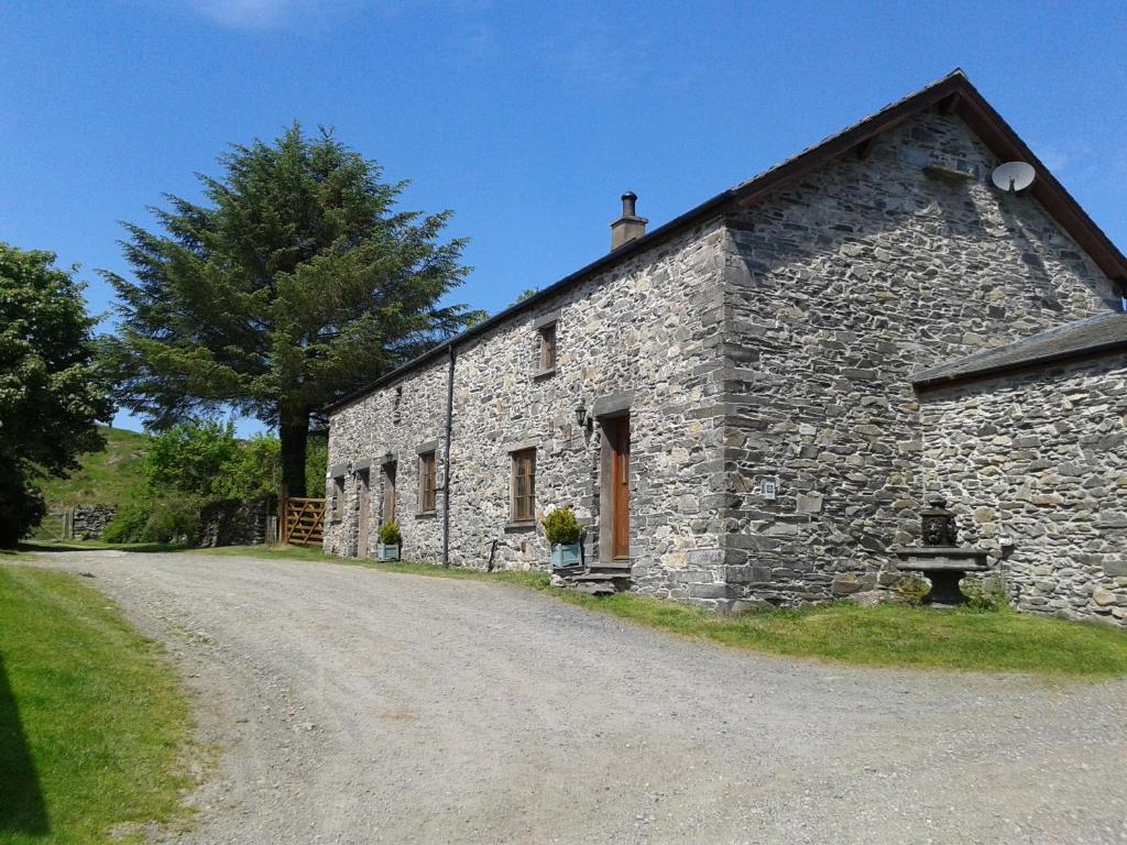 um edifício de pedra numa estrada de terra em Thornthwaite Farm em Broughton in Furness