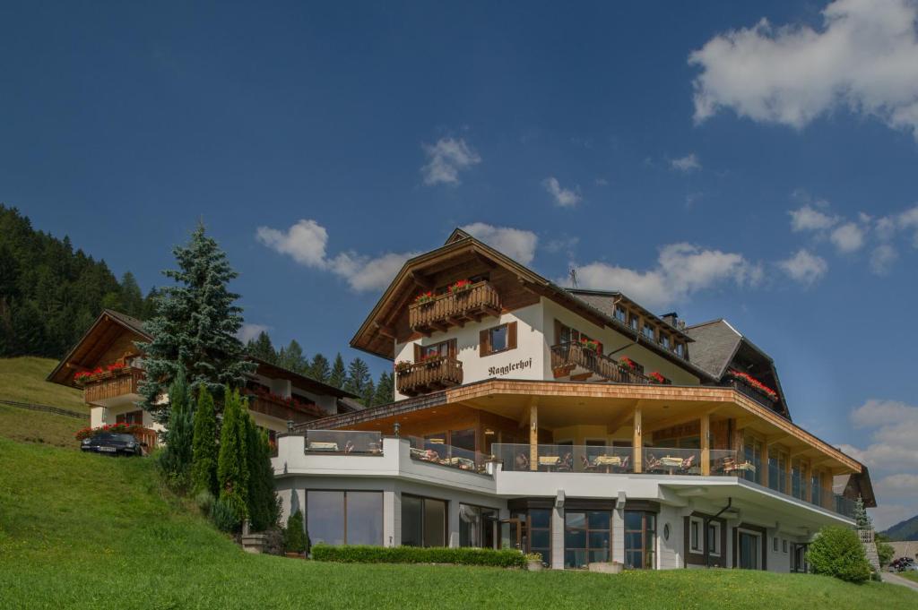 a large house on top of a hill at Hotel Nagglerhof am Weissensee in Weissensee