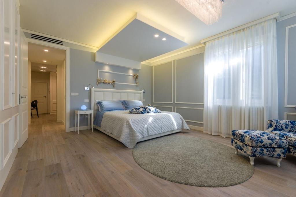 a bedroom with a bed and a chair at Cervia Marina Suite in Cervia