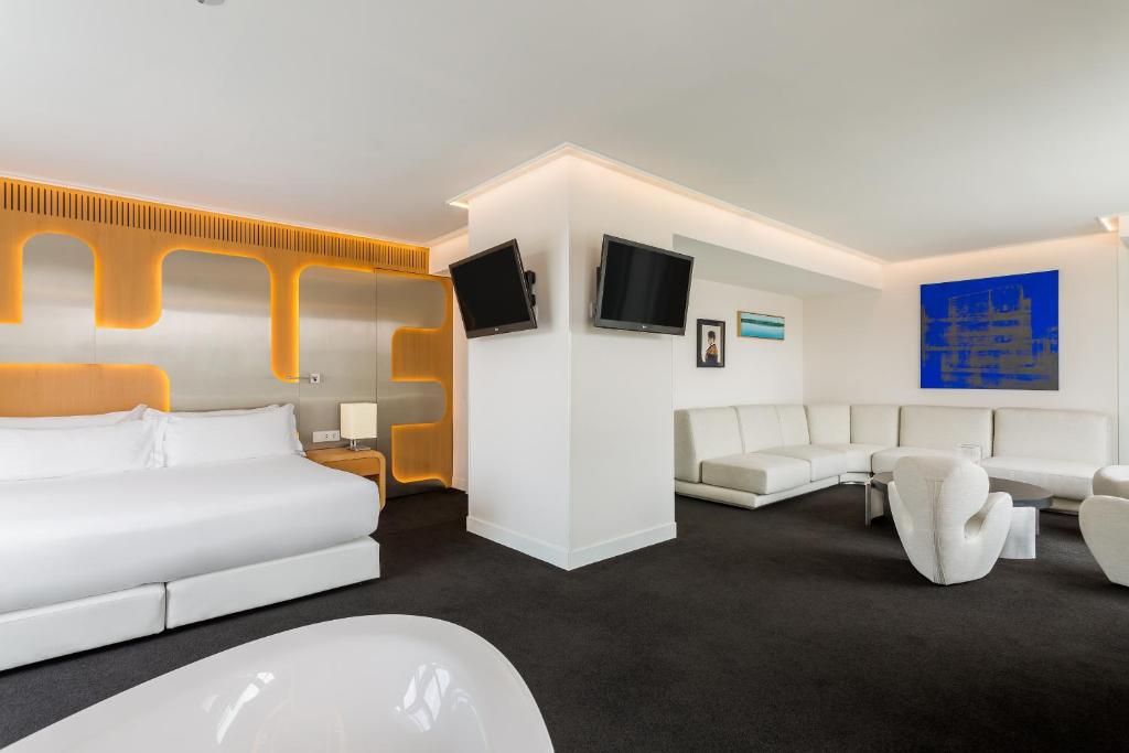 a hotel room with two beds and couches at Room Mate Oscar, Madrid in Madrid