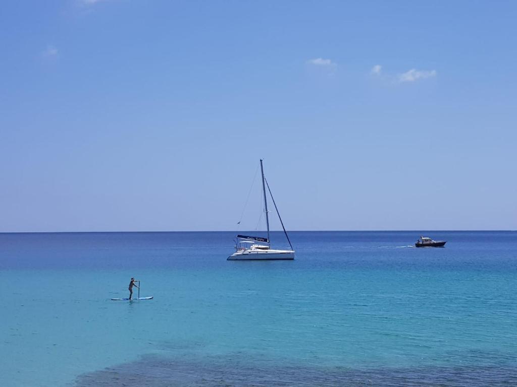 a person on a surfboard in the water with boats at Your Ocean Window in Costa Calma