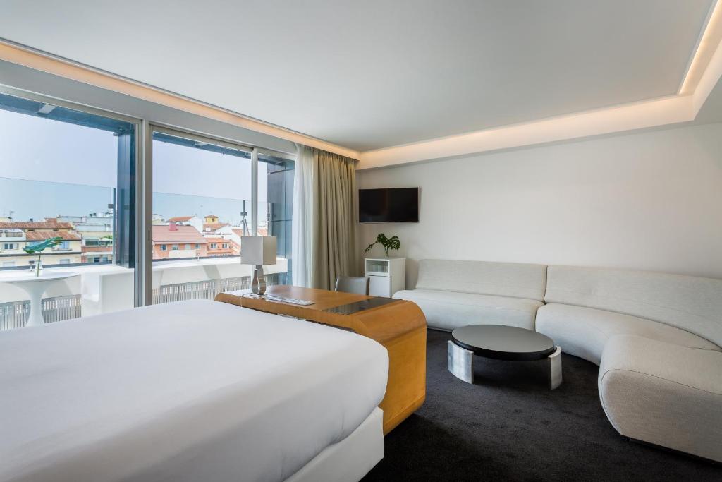 a hotel room with a bed and a couch at Room Mate Oscar, Madrid in Madrid