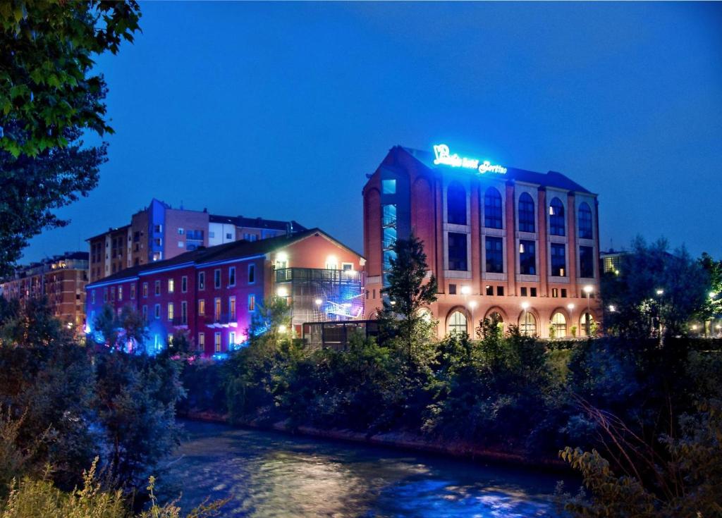 a building with a sign on top of it at night at Pacific Hotel Fortino in Turin