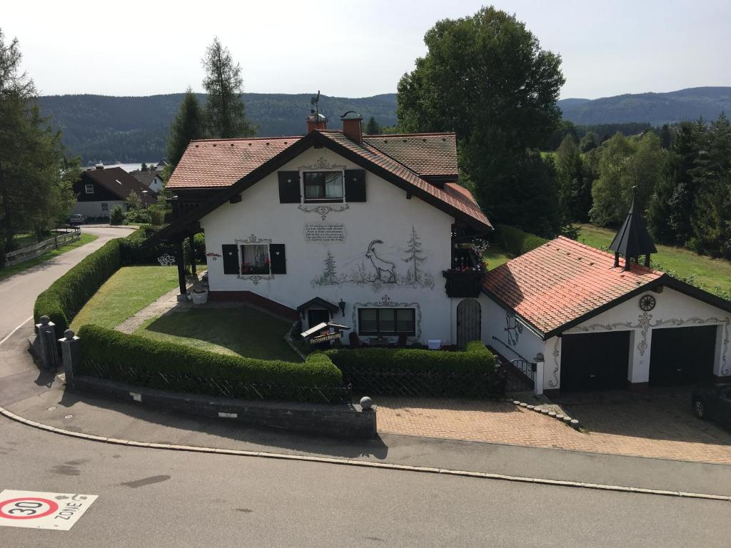 una casa blanca con techo rojo en una calle en Ferienhaus Haber, en Schluchsee