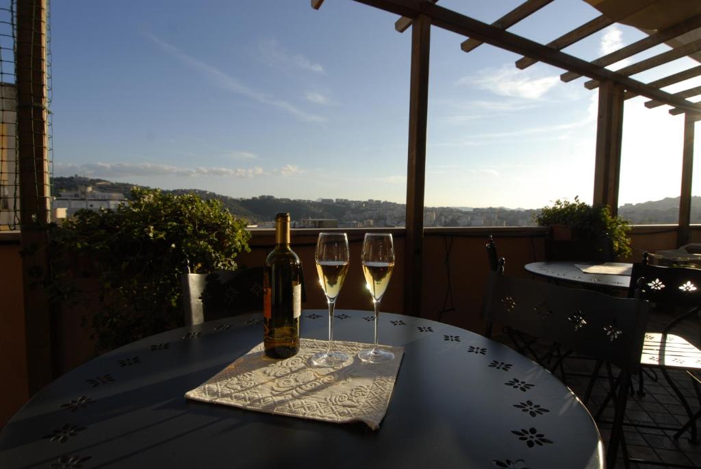 a table with two wine glasses and a bottle of wine at Nughe 'e' Oro Guesthouse in Nuoro