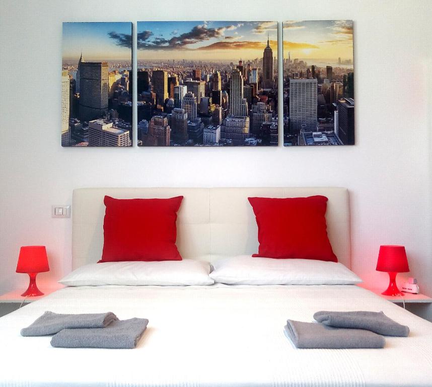 a bedroom with a white bed with red pillows at Panoramic Plaza Apartment -Loreto 1 in Milan