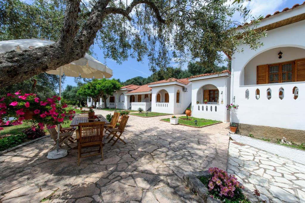 a patio with a table and chairs under a tree at Nefeli Studios in Parga