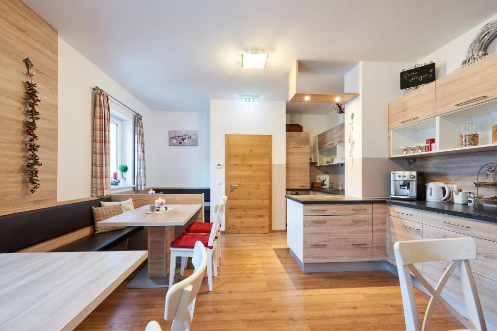 a kitchen with wooden floors and a table and chairs at Pension Gschaider in Payerbach