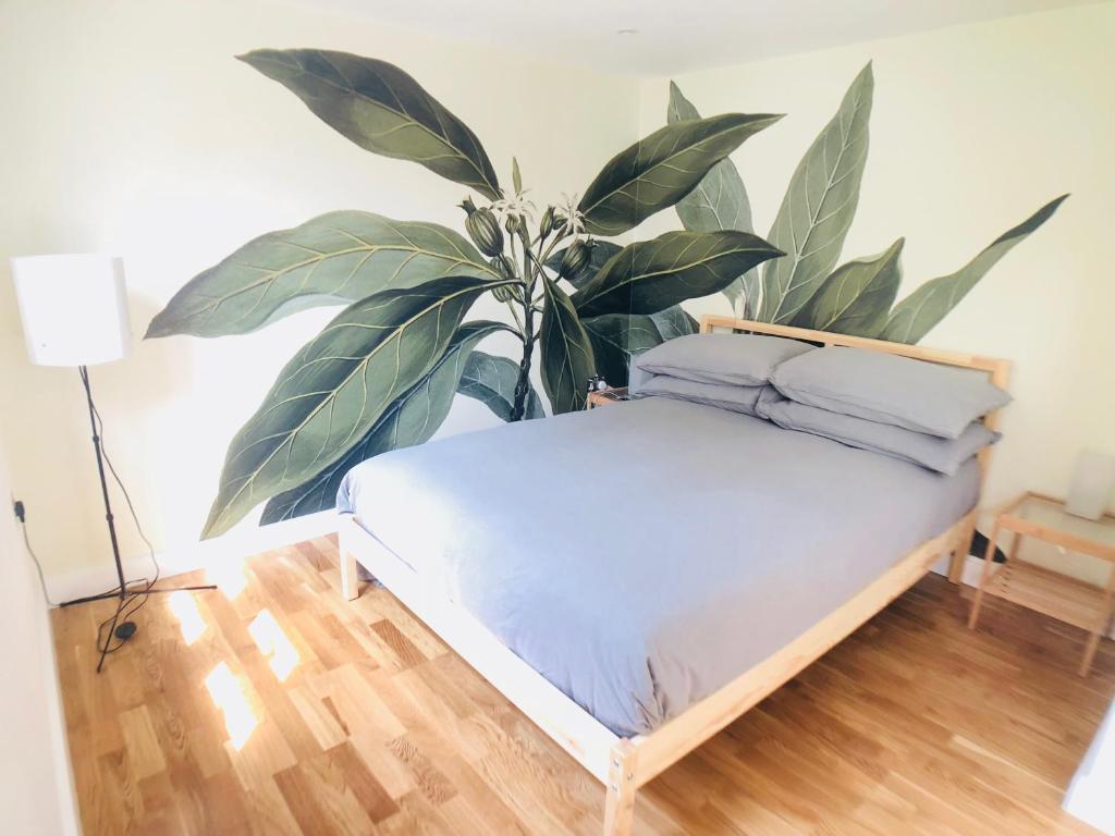 a plant sitting next to a bed in a room at Camden Town Garden Cabin in London