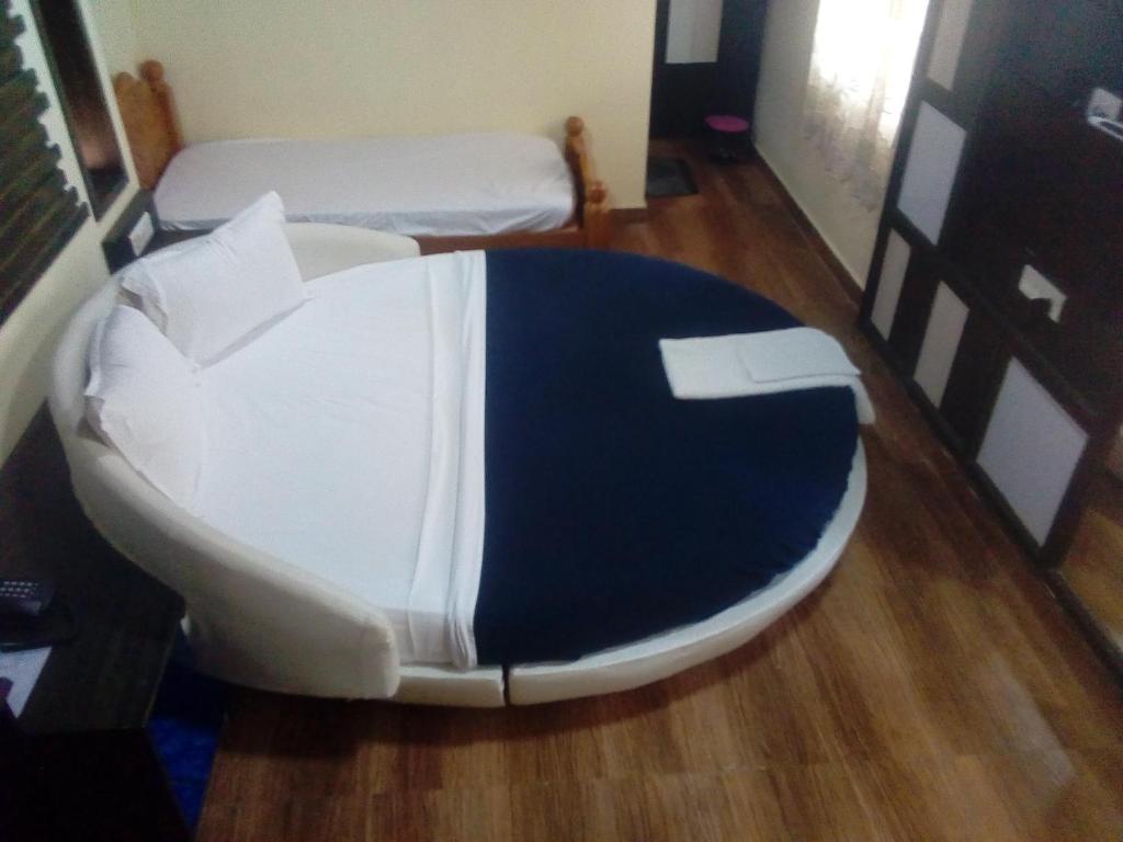 Postel nebo postele na pokoji v ubytování Hotel Anandhiram Heritage