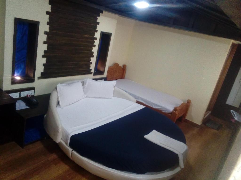 Postel nebo postele na pokoji v ubytování Hotel Anandhiram Heritage