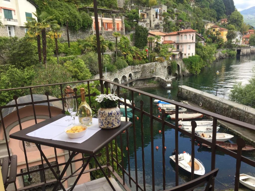a balcony with a table and a view of a river at Al vecchio porto casa a Cannero in Cannero Riviera