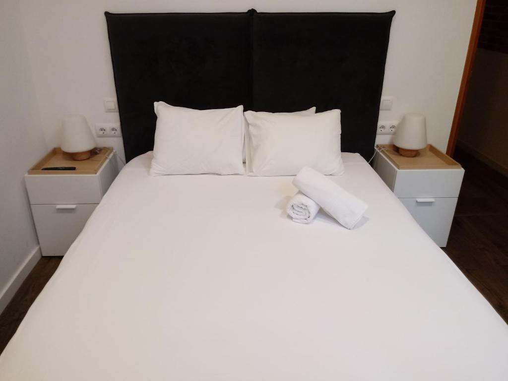 バルセロナにあるNiM Eixample 5のベッドルーム1室(白い大型ベッド1台、ナイトスタンド2台付)
