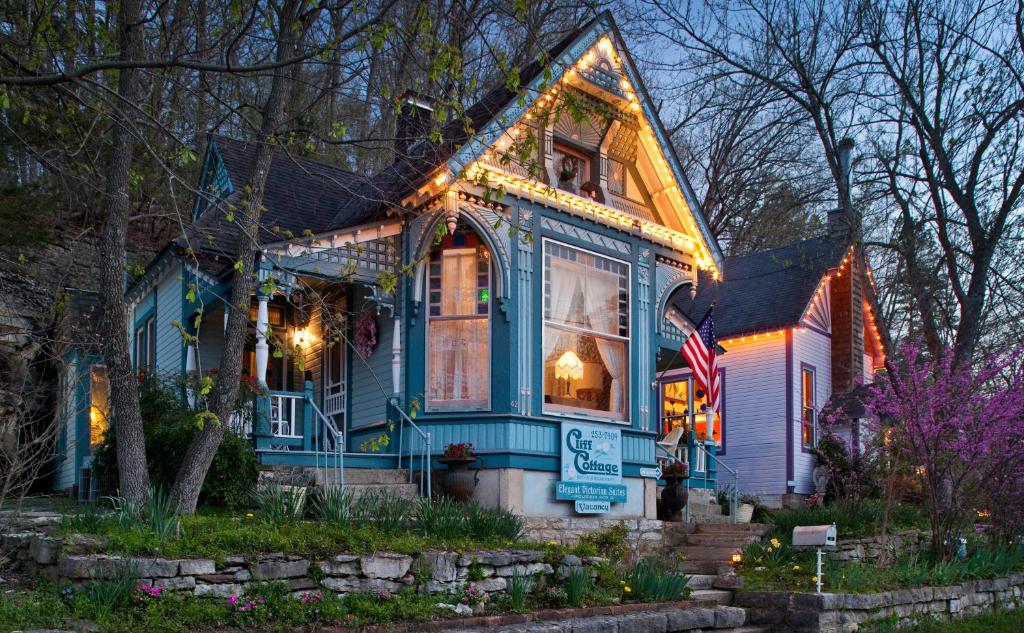 Uma casa azul com luzes de Natal em Cliff Cottage Inn em Eureka Springs