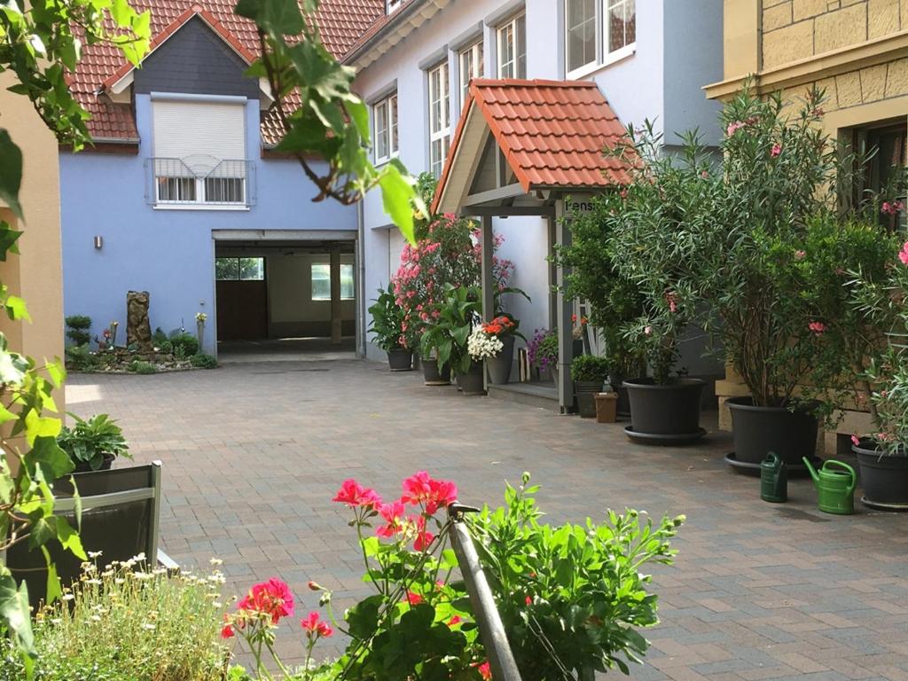 a courtyard of a house with flowers and plants at Pension am Schlossberg in Reichenberg