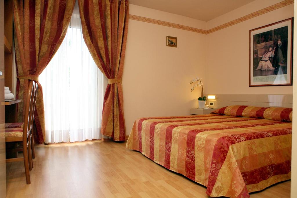 a hotel room with a bed and a window at Hotel Excelsior in Monfalcone