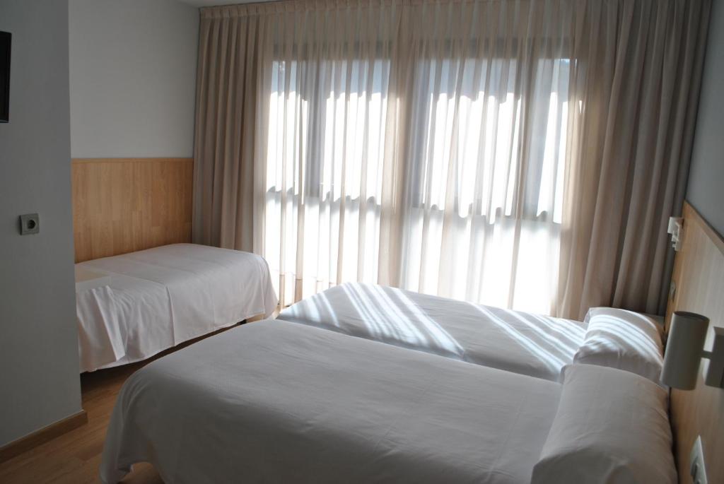 Postel nebo postele na pokoji v ubytování Hostal Universitat