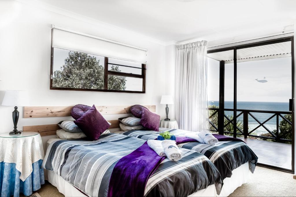 a bedroom with a bed with a view of the ocean at At Whale-Phin Guest House in Reebok