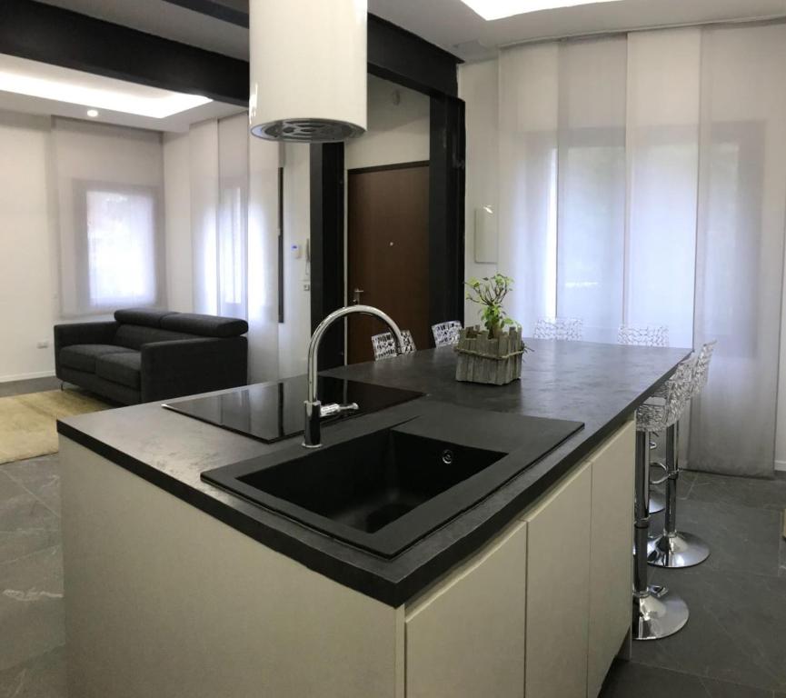 eine Küche mit einem Waschbecken und ein Wohnzimmer in der Unterkunft Venetian Aesthetic Apartment in Mestre