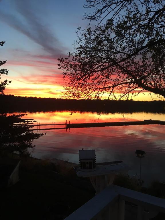 un coucher de soleil sur un lac avec un bateau dans l'eau dans l'établissement Victoria Harbour Cottages, à Victoria Harbour