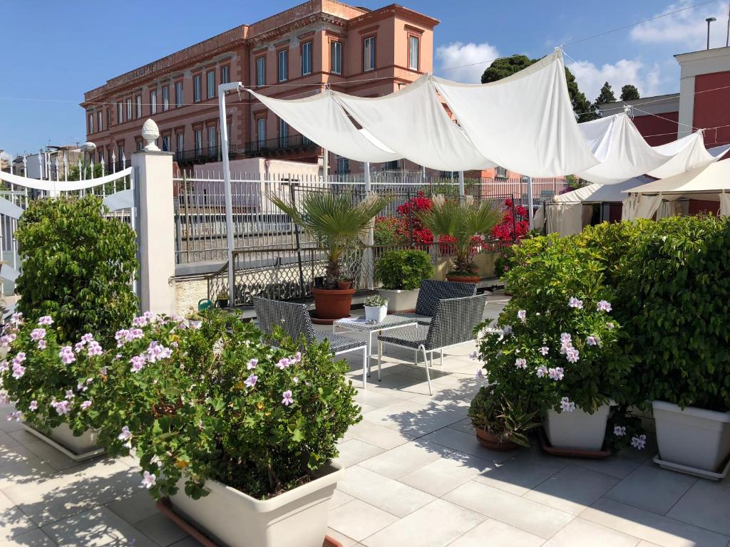 a patio with potted plants and a white canopy at Golden Mile B&B in Ercolano