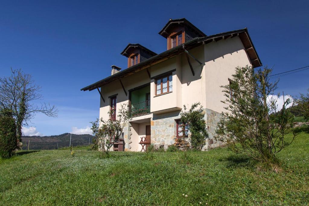 una casa en una colina con un campo verde en Casa de Aldea Carboneiro, en Naraval