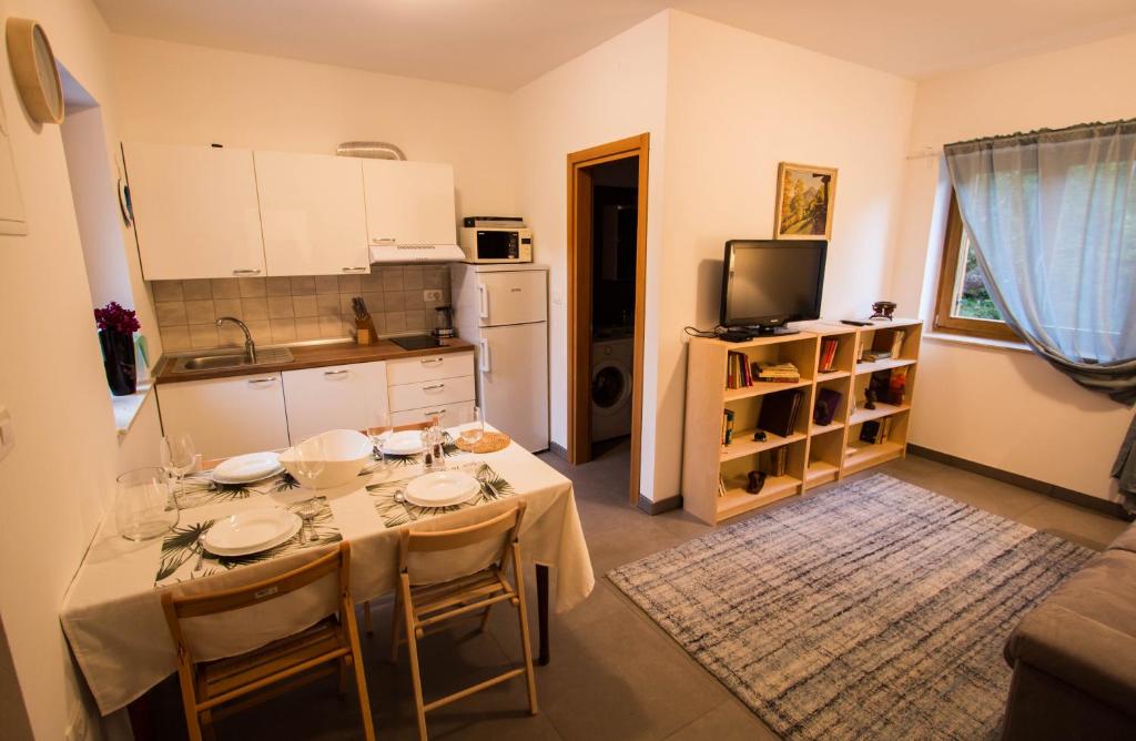 a kitchen with a table with chairs and a kitchen at Apartment Lucia in Lucija