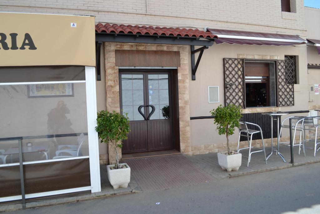 Hostal Pension La Ruta في Paterna del Campo: مطعم فيه طاولات وكراسي امام باب