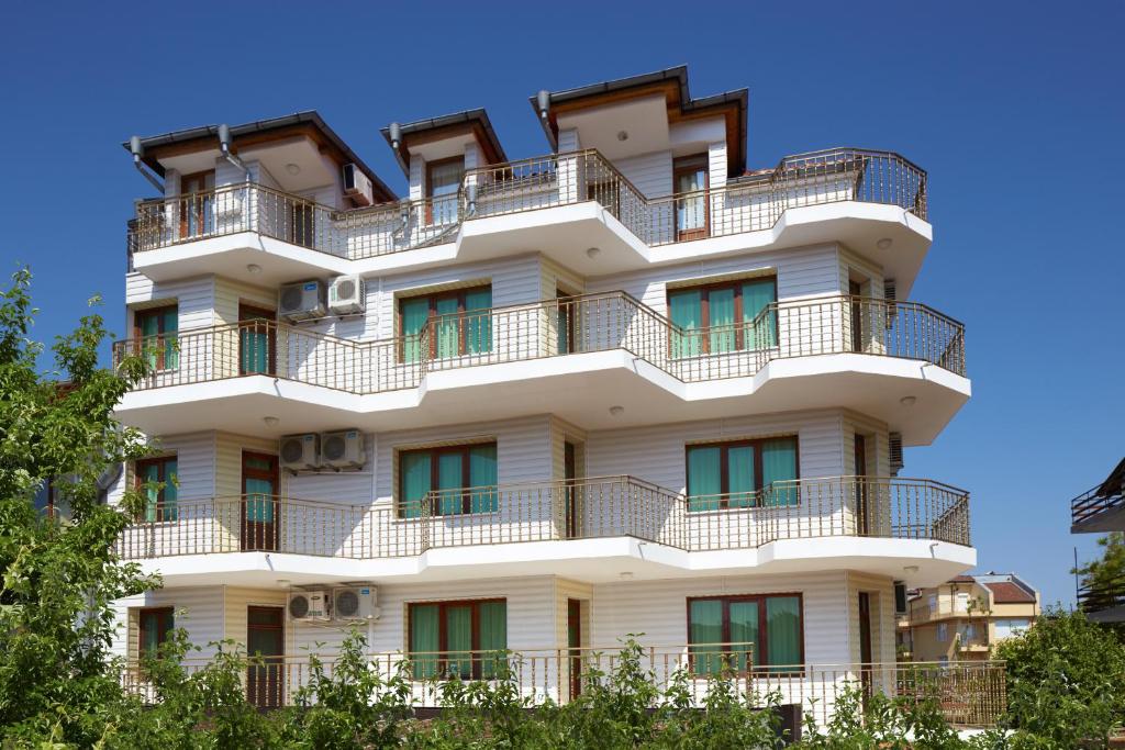 ein hohes weißes Gebäude mit Balkonen darauf in der Unterkunft Gloria Holiday House in Nessebar
