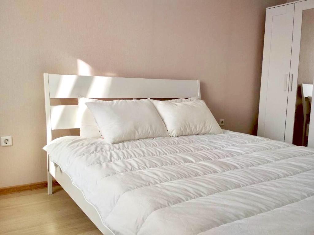 a white bed with white sheets and pillows at Парк Университет Exclusive МоМеНтАлЬнОе БЕСКОНТАКТНОЕ ЗАСЕЛЕНИЕ in Vladimir