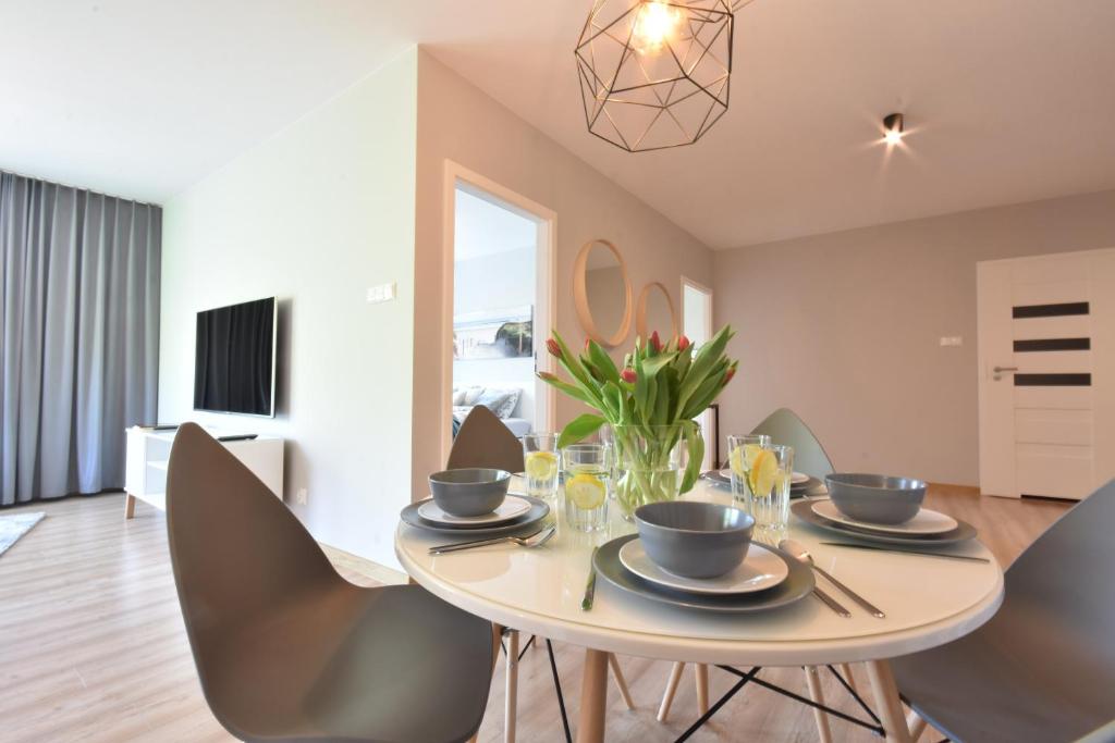 a dining room with a table and chairs at Wolski Apartments - Polanki Park 303 in Kołobrzeg