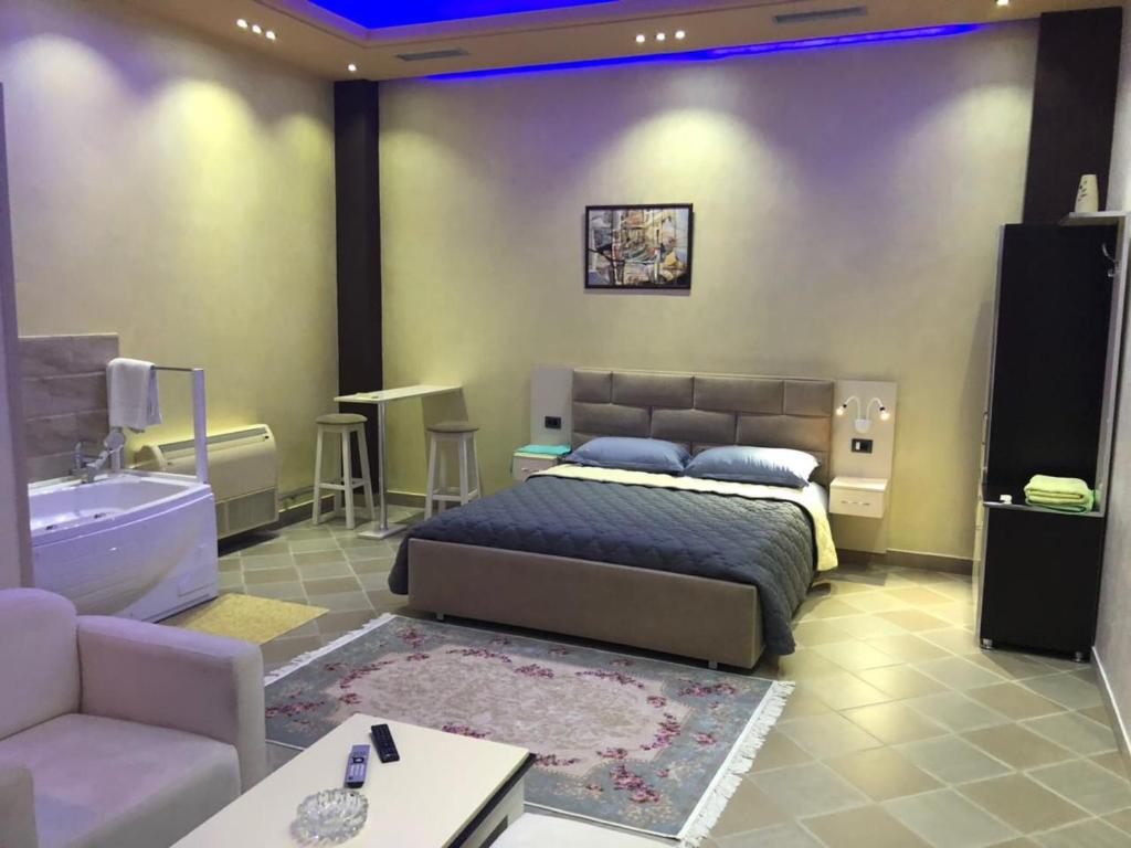 a bedroom with a bed and a couch and a tub at Hotel Jurgen in Lezhë