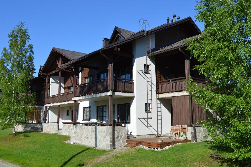 a large white house with a porch and balcony at Pointin Vale Apartment Tahko in Tahkovuori