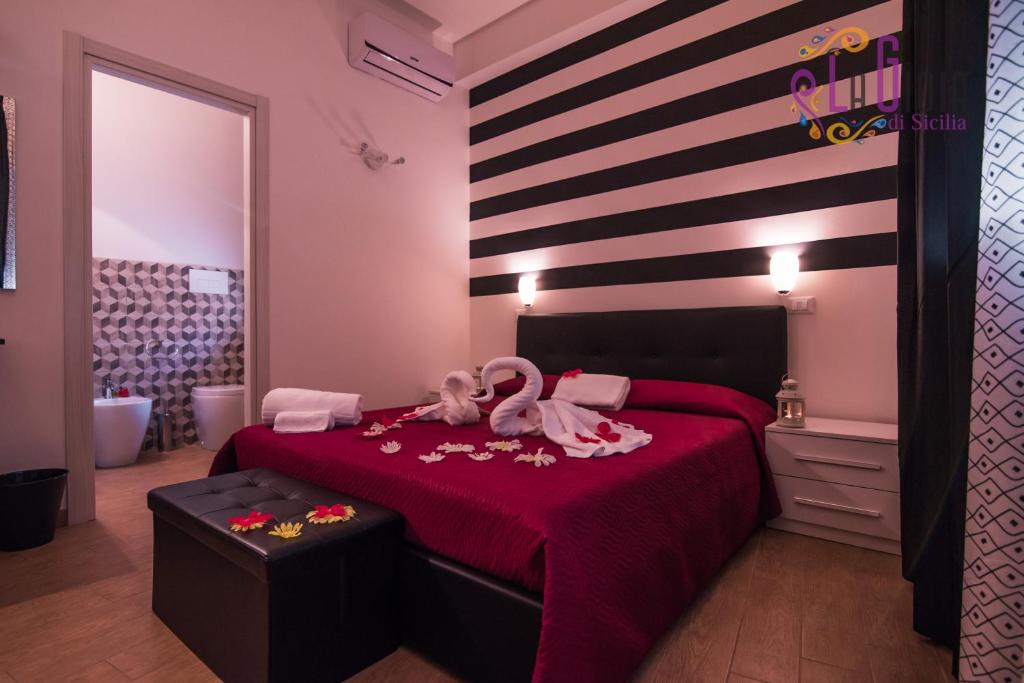 アヴォラにあるLa Gioia di Sicilia B&Bのベッドルーム1室(白鳥の赤いベッド1台付)