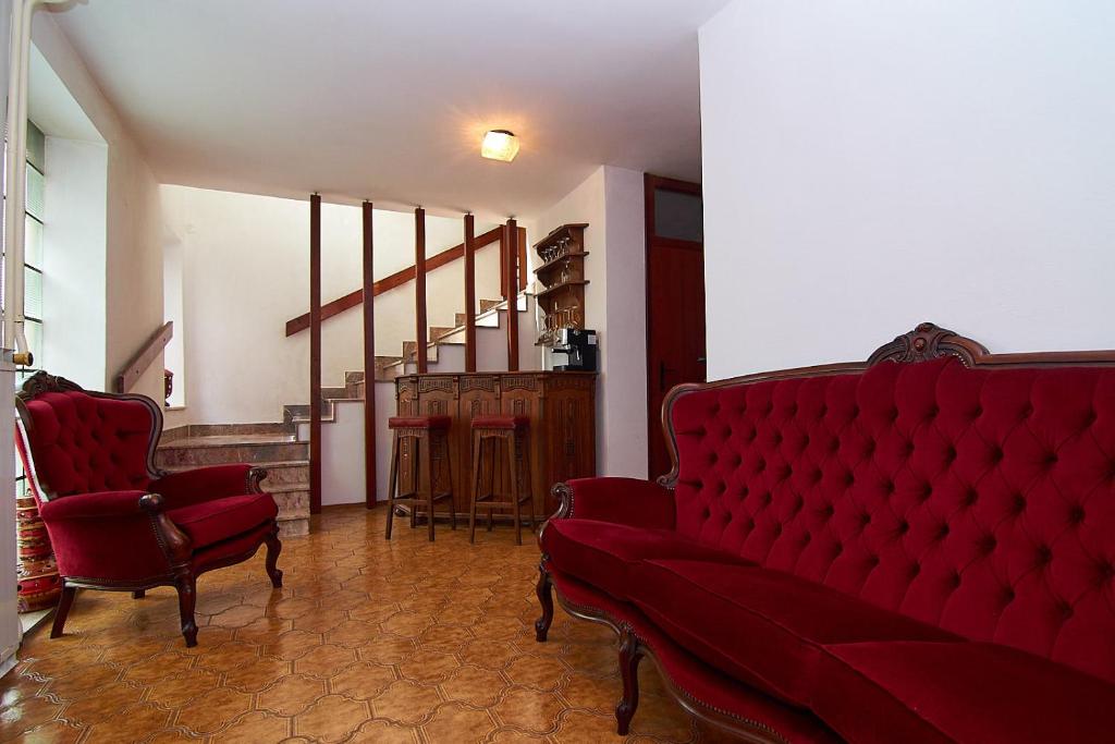 - un salon avec un canapé rouge et deux chaises dans l'établissement Emona Apartments, à Ljubljana