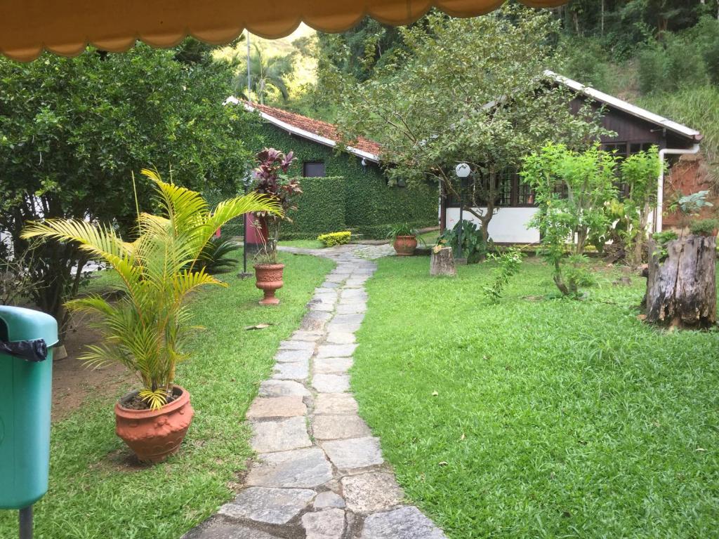 a garden with potted plants and a stone path at Hotel Colonial in Piraí