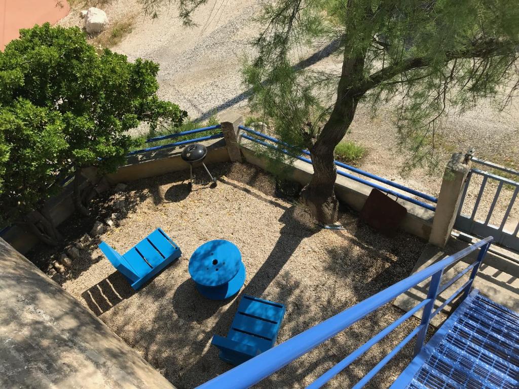 an overhead view of a playground with blue chairs and a tree at Port saint Louis du Rhône magnifique vue sur mer in Saint-Louis-du-Rhône