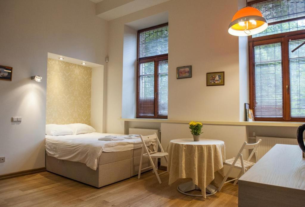 una camera con letto, tavolo e sedie di Teatro Apartments a Vilnius