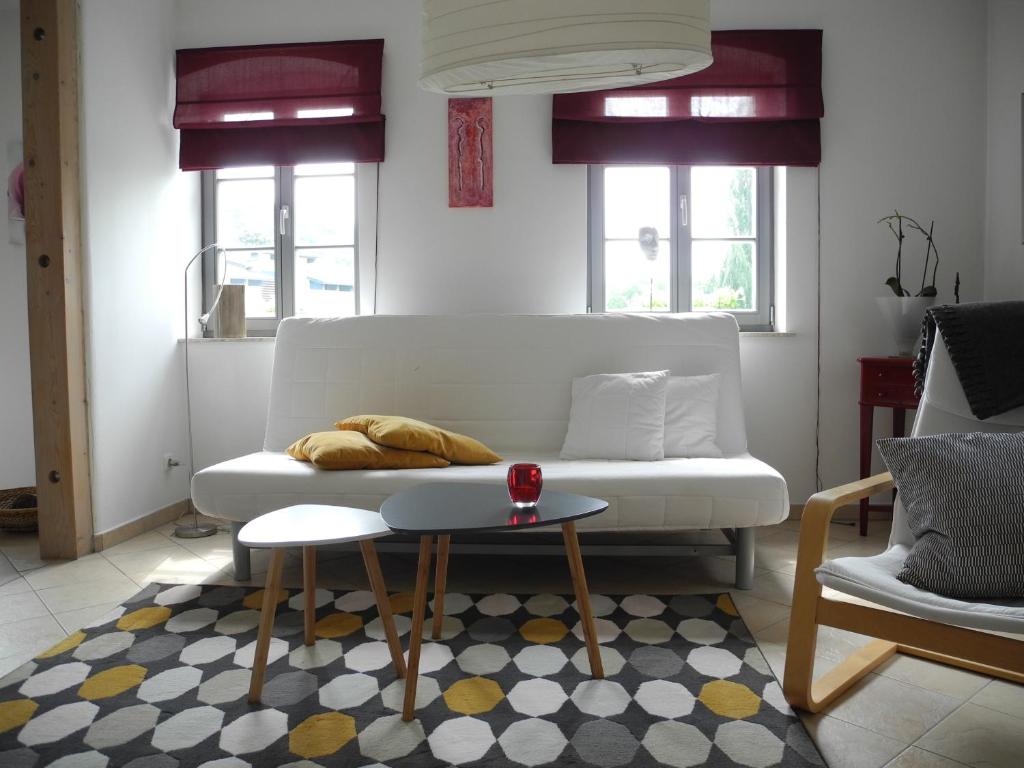 uma sala de estar com um sofá branco e uma mesa em Ferienwohnung Geißler em Radebeul